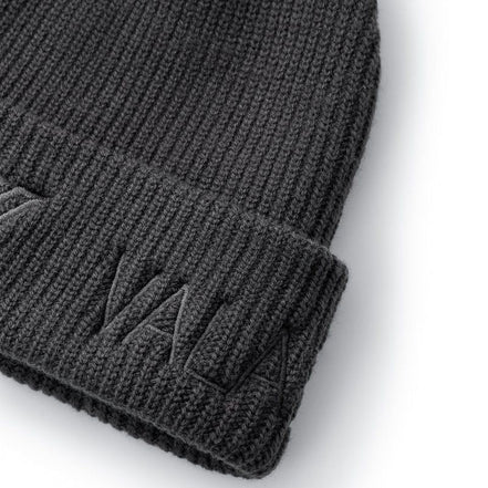 Close-up of a dark gray ribbed knit beanie with a folded cuff and tonal embroidered logo on a white background.