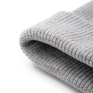 A close-up of a folded light gray ribbed knit fabric, showing the texture and weave detail against a clean white background.