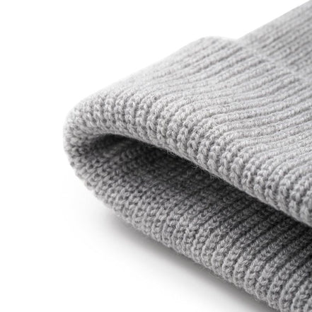 A close-up of a folded light gray ribbed knit fabric, showing the texture and weave detail against a clean white background.