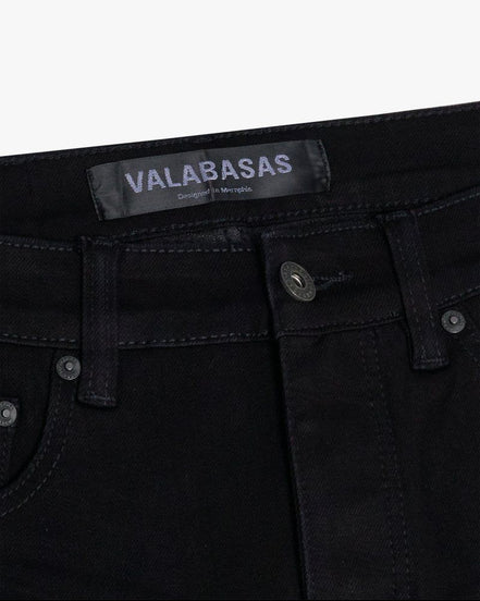 Black jeans with 'VALABASAS' label on a white background
