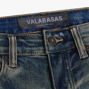 Close-up of blue jeans with a visible brand label on a white background