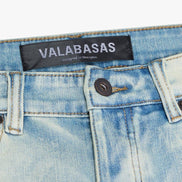 Close-up of a denim garment with 'VALABASAS' label on a white background