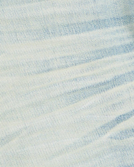 Close-up of light blue denim fabric with a subtle pattern