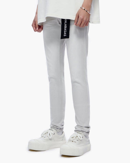 Person wearing light gray jeans with a brand logo on a white background