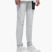 Light gray pants with a brand label worn by a person on a white background