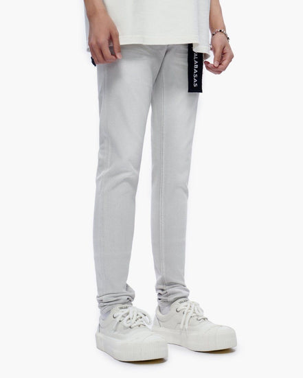 Light gray pants with a brand label worn by a person on a white background