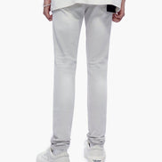 Person wearing light gray pants and white sneakers on a white background