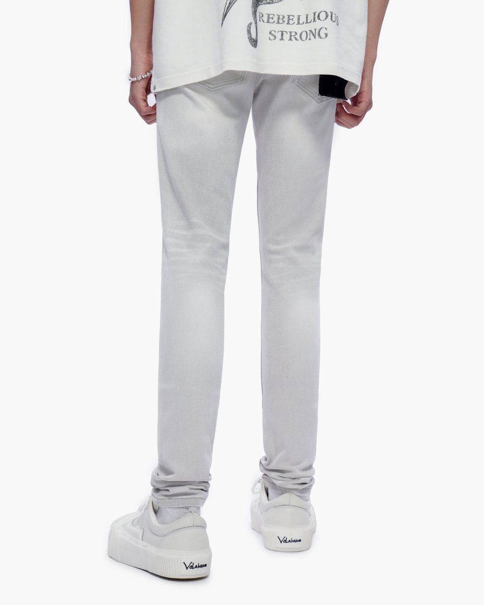Person wearing light gray pants and white sneakers on a white background