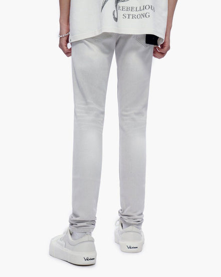 Person wearing light gray pants and white sneakers on a white background