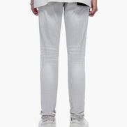 Person wearing light gray pants and a white shirt with text on a white background