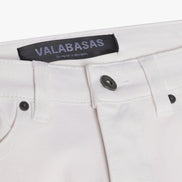 Close-up of white pants with a visible brand label on a white background
