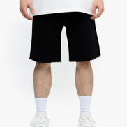 Person wearing black shorts and white sneakers on a white background