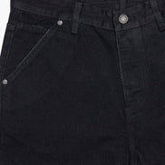 Close-up of black pants with a visible brand label on a white background
