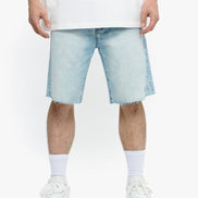 Person wearing light blue denim shorts and white sneakers on a white background