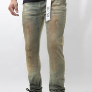 Person wearing green distressed jeans with a visible brand tag on a white background