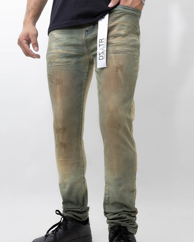 Person wearing green distressed jeans with a visible brand tag on a white background