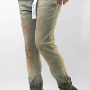 Person wearing light green jeans and black shoes on a white background