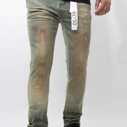 Person wearing green distressed jeans with a visible brand label on a white background
