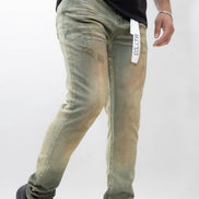 Person wearing green distressed jeans with a visible brand tag on a white background