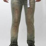 Person wearing green distressed jeans with a visible brand label on a white background