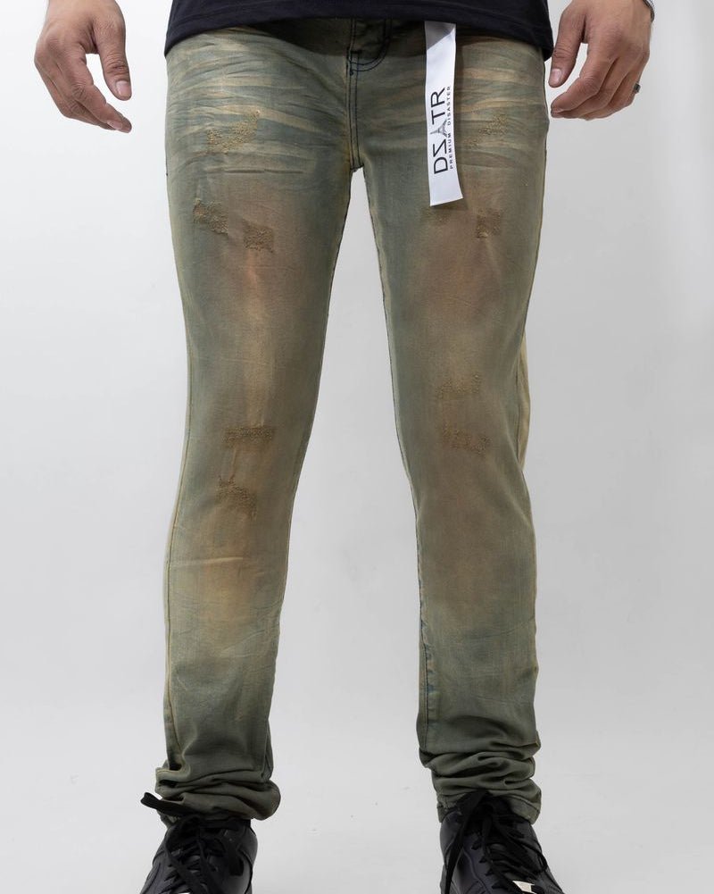 Person wearing green distressed jeans with a visible brand label on a white background