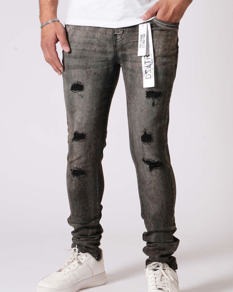 Person wearing gray distressed jeans with white sneakers on a white background