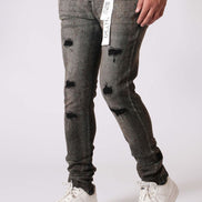 Person wearing distressed black jeans and white sneakers on a white background