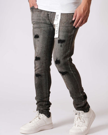 Person wearing distressed black jeans and white sneakers on a white background