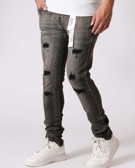 Person wearing distressed black jeans and white sneakers on a white background
