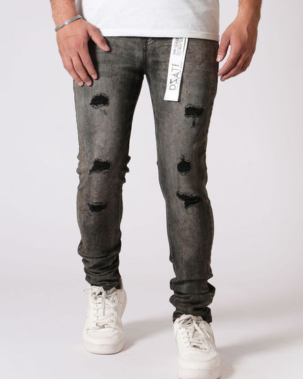 Person wearing distressed gray jeans with a white background