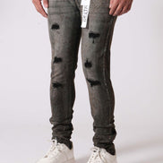 Person wearing gray distressed jeans and white sneakers on a white background