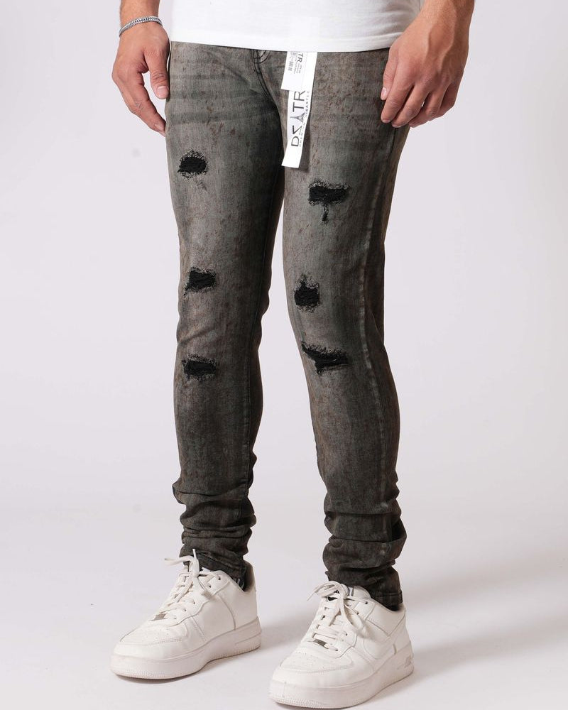 Person wearing gray distressed jeans and white sneakers on a white background