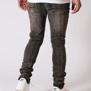 Person wearing dark gray jeans and white sneakers on a white background