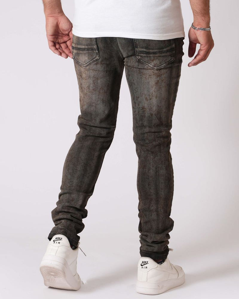 Person wearing dark gray jeans and white sneakers on a white background