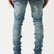 Person wearing blue jeans and white sneakers on a plain background