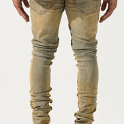 Person wearing light brown distressed jeans on a white background