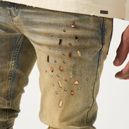 Close-up of beige pants with decorative studs on a white background