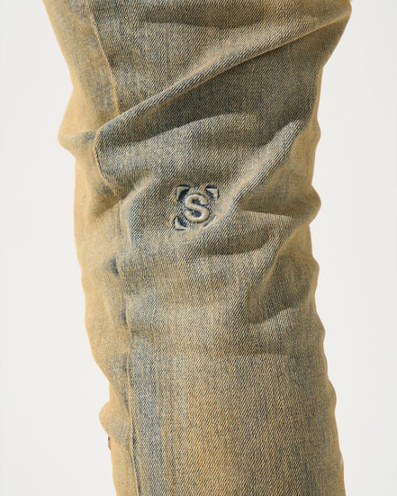 Close-up of beige pants with a logo on a white background