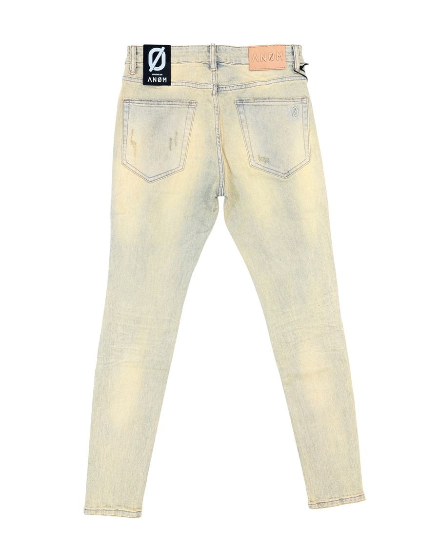 Back view of light-wash distressed skinny jeans with a black and white brand patch on the back waistband and a tan leather patch on the right side.