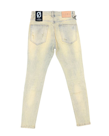 Back view of light-wash distressed skinny jeans with a black and white brand patch on the back waistband and a tan leather patch on the right side.