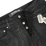 Close-up of black jeans with brand labels on a white background