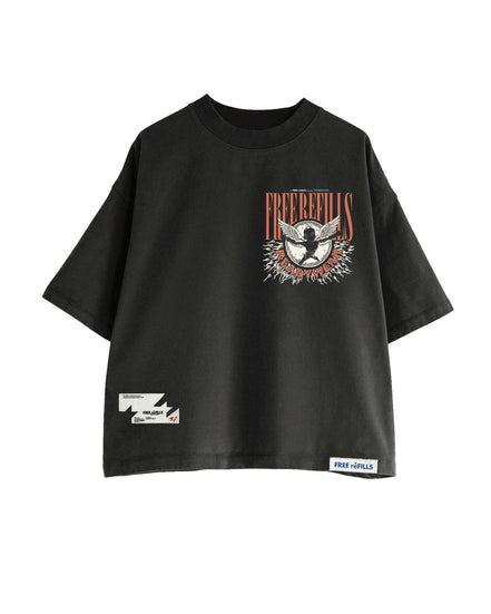 A black oversized short-sleeve t-shirt with a distressed graphic on the left chest featuring a bird and the text 'FREE REFILLS'. It has a small white graphic patch on the lower left sleeve and a white brand label on the lower right hem.