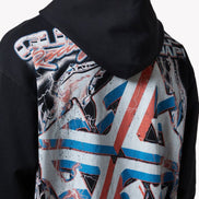 Person wearing a black hoodie with a colorful geometric pattern on the back