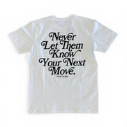 White t-shirt with black text 'Never Let Them Know Your Next Move' on a white background
