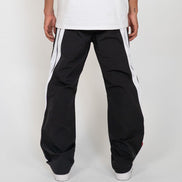 Person wearing black pants with white stripes on a white background