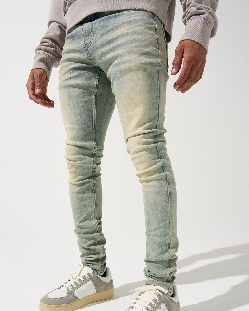 Person wearing light blue jeans and white sneakers on a white background
