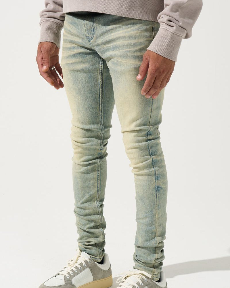 Person wearing light blue jeans and white sneakers on a white background