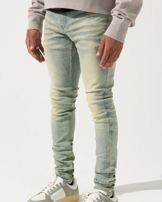 Person wearing light blue jeans and white sneakers on a white background