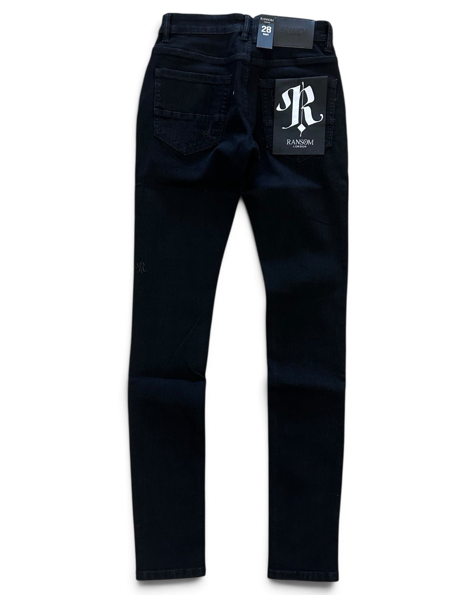 Dark navy blue slim-fit jeans shown from the back, featuring a white 'JR RANSOM' logo patch on the back pocket and a brand tag at the waistband, set against a plain white background.
