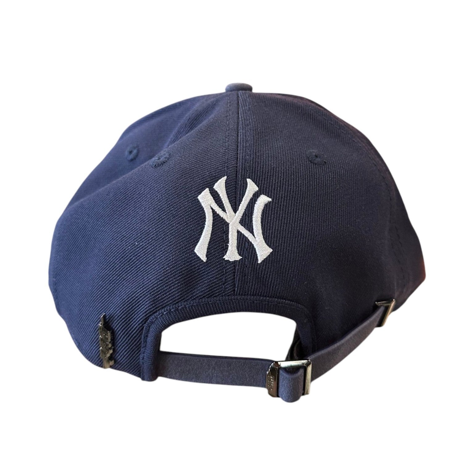 Navy blue baseball cap with white logo on a white background